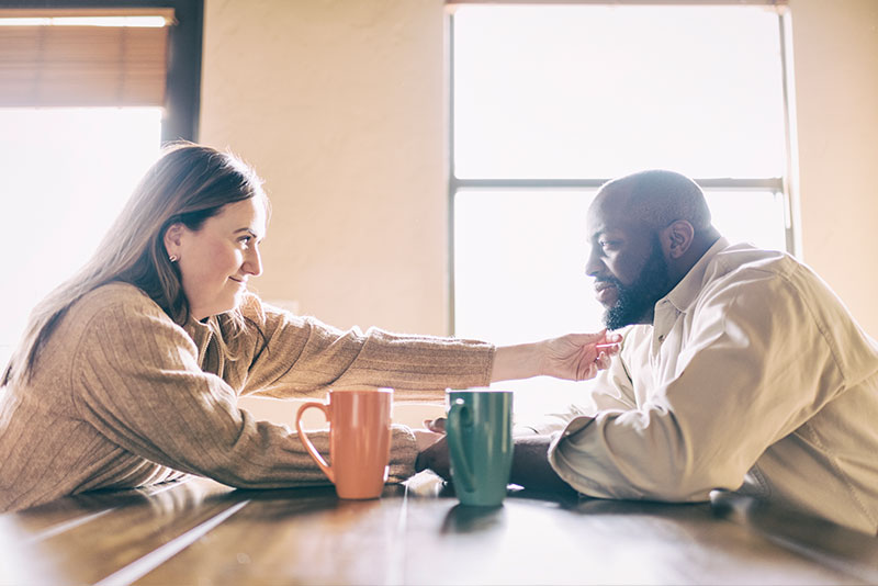 Couple holding hands across the table